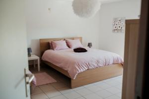 普罗丰德维耶Les 4 Arbres的一间卧室配有带粉红色枕头的床