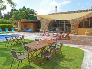 卡斯特罗·德波利亚斯Masia Ca La Caputxeta & Golf的一个带桌椅的庭院和一个游泳池