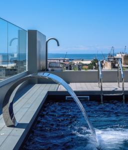 塞萨洛尼基ONOMA Hotel的一座建筑中一个带两个喷泉的游泳池