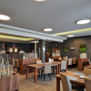 Moravský Žižkov玛德里奇旅馆的用餐室配有木桌和椅子