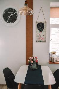 利耶帕亚LUCKY 7 apartment的餐桌,带时钟和花瓶