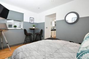 利兹Modern studio apartment in Leeds City Centre (LS1)的一间带床和镜子的卧室以及一间厨房