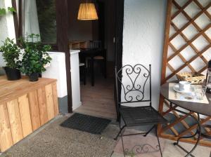 埃尔毛Oberholzer Landhaus & Appartement的坐在门前的一张黑椅子