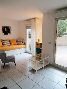 尼斯Studio neuf 25 m2, terrasse 35 m2 proche port Nice, Centre ville的客厅配有床和玻璃桌