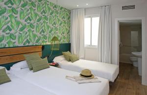 巴塞罗那Chic & Basic Lemon Boutique Hotel的酒店客房带两张床和一间浴室