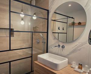 Ivry-le-Temple德连考特莱斯农庄旅馆的浴室配有盥洗盆和带镜子的淋浴