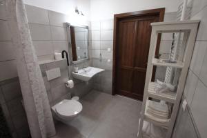 KéthelyA tornácos panzió的一间带卫生间、水槽和镜子的浴室