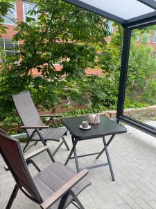 埃姆登Möwenhaus的庭院配有两把椅子、一张桌子和一张桌子以及椅子。