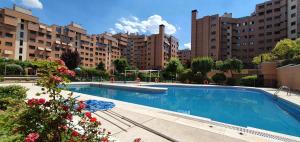 马德里Residencial Caliza的一座大型游泳池,位于部分建筑前
