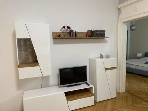 维也纳MQ Appartement的一间客厅,在白色的橱柜上配有电视