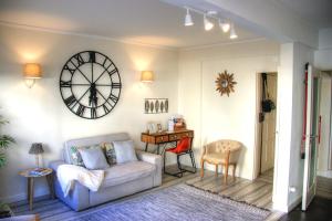 卡尔卡维洛斯Beachome4u的客厅配有沙发和墙上的时钟