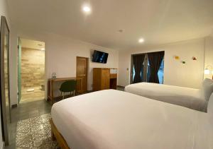 墨西哥城Hotel MX condesa的酒店客房配有两张床和一张书桌