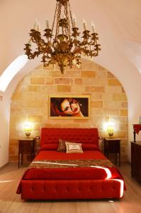 科佩尔蒂诺Casa a Corte的一间卧室配有一张红色的床和吊灯。