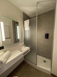 克莱蒙费朗B&B HOTEL Clermont-Ferrand A71-A75 La Méridienne的带淋浴、盥洗盆和镜子的浴室