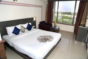 艾哈迈达巴德银云和宴会酒店的卧室配有带蓝色枕头的大型白色床