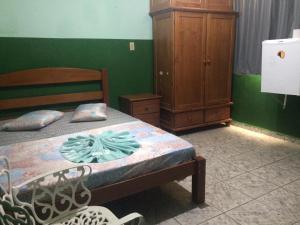 容迪亚伊Hotel Marabá的一间卧室配有一张床和一个木制橱柜