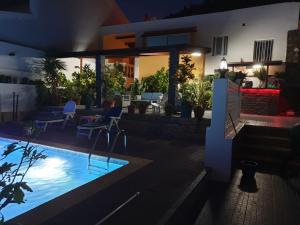 Cidade VelhaCactus Guest House的一座晚上设有游泳池的房子