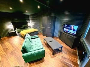 CarrYaseva Lodge, Stylish Country Retreat for 2, Hot Tub, Exceptional Views!的一间卧室配有一张床、一张沙发和一台电视。