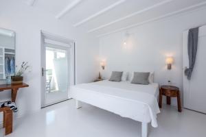 凯特利奥斯Casa Montzo boutique hotel的白色的卧室设有白色的床和窗户。