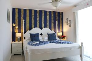 伯利兹城波斯卡迪别墅 的卧室配有带蓝色枕头的大型白色床