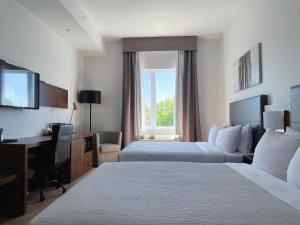 魁北克市Quality Inn的酒店客房配有两张床和一张书桌