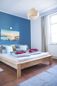 米德尔哈根Ferienwohnung in der Brennerei Mönchgut的卧室设有两张床铺,拥有蓝色的墙壁