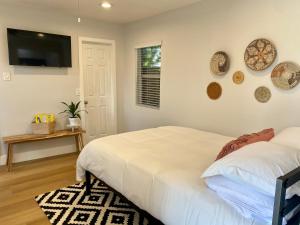亨廷顿海滩Steps To The Beach, Pacific City and Main Street - Studio的卧室配有一张床,墙上配有电视。