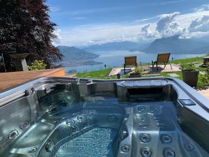 斯特雷萨Private Luxury Spa & Silence Retreat with Spectacular View over the Lake Maggiore的享有水景的热水浴池