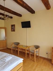 TvarožnáAndrišov dom penzion的一间卧室配有桌椅和墙上的电视。