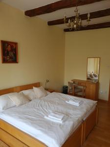 TvarožnáAndrišov dom penzion的一间卧室配有一张带白色床单和一张桌子的床。
