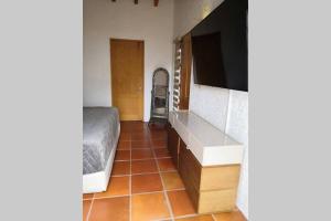 库埃纳瓦卡Casa Luna con alberca privada的卧室配有1张床和1台电视,铺有瓷砖地板。