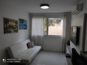 卡诺阿斯Lindo apartamento ao lado do Park Shopping Canoas的客厅配有白色沙发和窗户