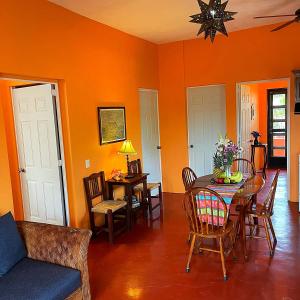 恰卡拉Casa Monarca的一间拥有橙色墙壁和桌椅的用餐室