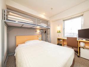 东京野御徒町超级酒店的卧室配有一张白色大床、一张书桌和窗户。