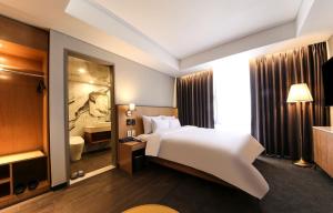 光州Gwangju HOUND Hotel的酒店客房设有白色的床和浴室。