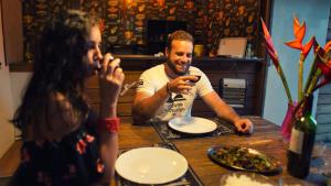 圣若瑟泡泡圆顶村酒店的坐在餐桌旁吃食物的男人和女人