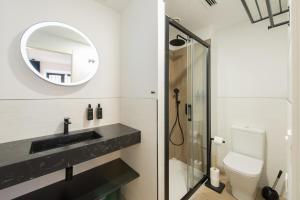 希洪Santa Catalina Suites Gijón的一间带水槽、镜子和卫生间的浴室