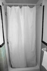 贝德福德贝德福德汽车旅馆的浴室内配有白色淋浴帘。
