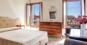威尼斯佩希恩赛古索酒店的一间卧室配有一张床、梳妆台和窗户。