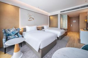铜仁铜仁万山假日酒店的酒店客房设有两张床和一张桌子。
