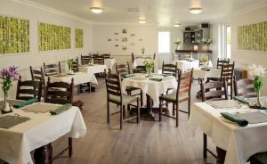 丁格尔希尔格罗夫旅馆 的一间设有白色桌椅的用餐室
