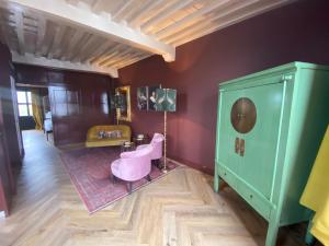 济里克泽Boutique Hotel Zeeuws-Meisje的一间设有粉红色椅子和绿色橱柜的房间