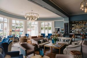 法尔茅斯绿岸酒店的带沙发和椅子的房间以及酒吧