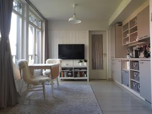 普雷拉Cosy modern apartment with lagoon view的客厅配有桌椅和电视。