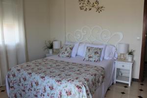 孔苏埃格拉Apartamentos Oncemolinos con desayuno的一间卧室配有一张带花卉床罩和枕头的床