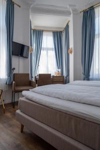 埃姆登阿尔特-埃姆德布格豪斯酒店的一间卧室配有一张带蓝色窗帘的大床