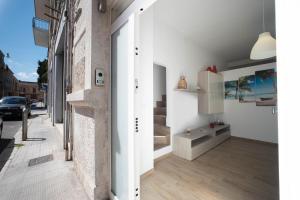 莫诺波利WePuglia - Casa Dolcissima的一间设有白色墙壁和木地板的客房,以及一座建筑