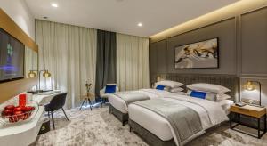 迪拜Rose Executive Hotel - DWTC的酒店客房配有两张床和一张书桌