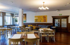 卡尔帕奇雷拉克斯康体SPA酒店的餐厅内带桌椅的用餐室