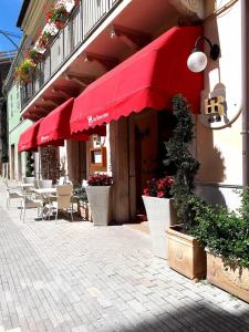 科玛南扎达罗维利诺餐厅酒店的一间设有红伞和桌椅的餐厅